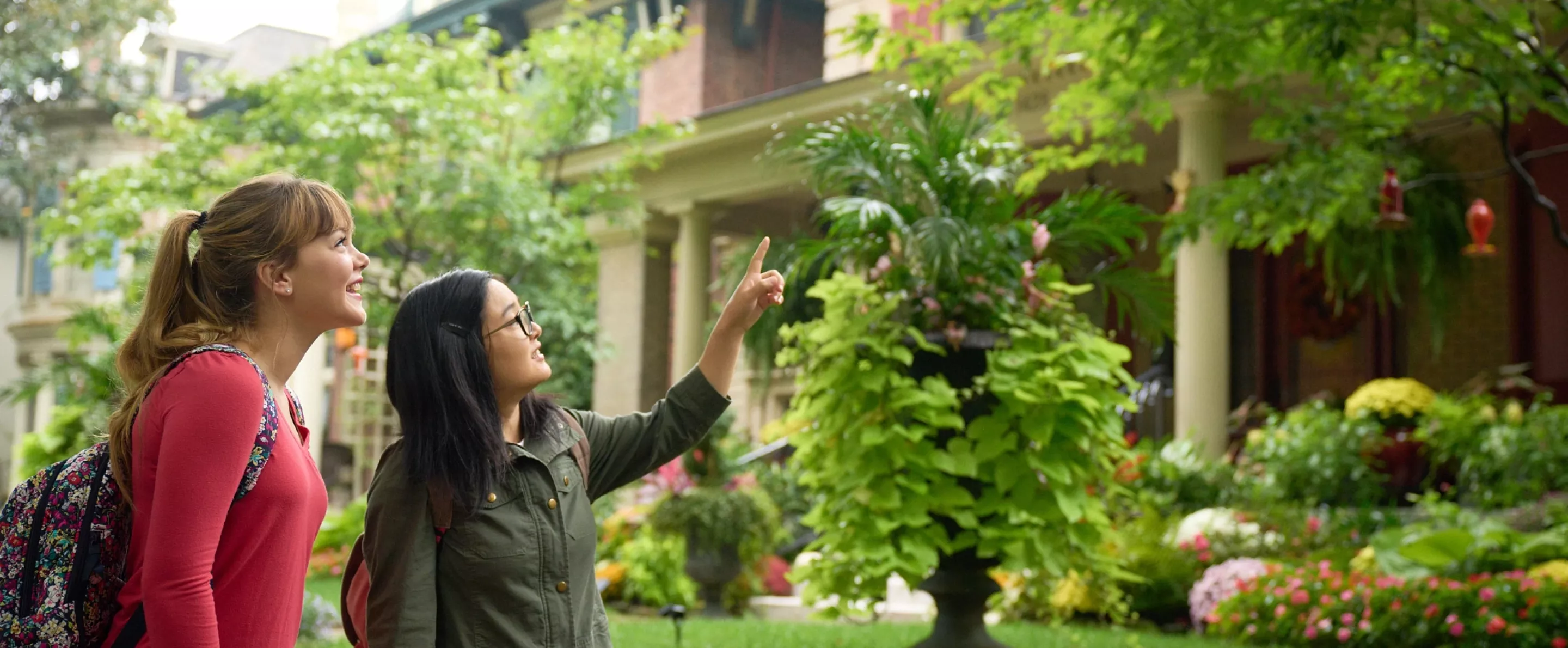 Two students walking through the Old Louisville neighborhood, looking at houses.