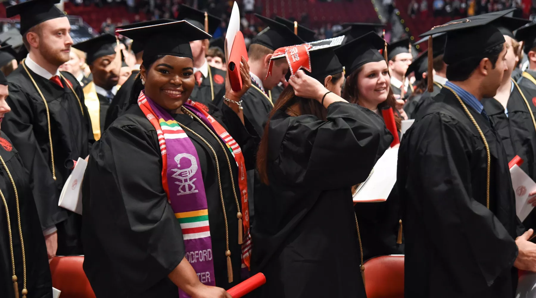 Student at commencement smiling and looking at the camera