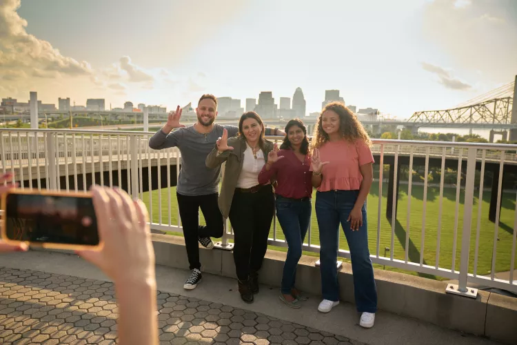 Students throwing up their L's for a group photo opportunity at the Big Four Bridge at Waterfront Park in downtown Louisville.