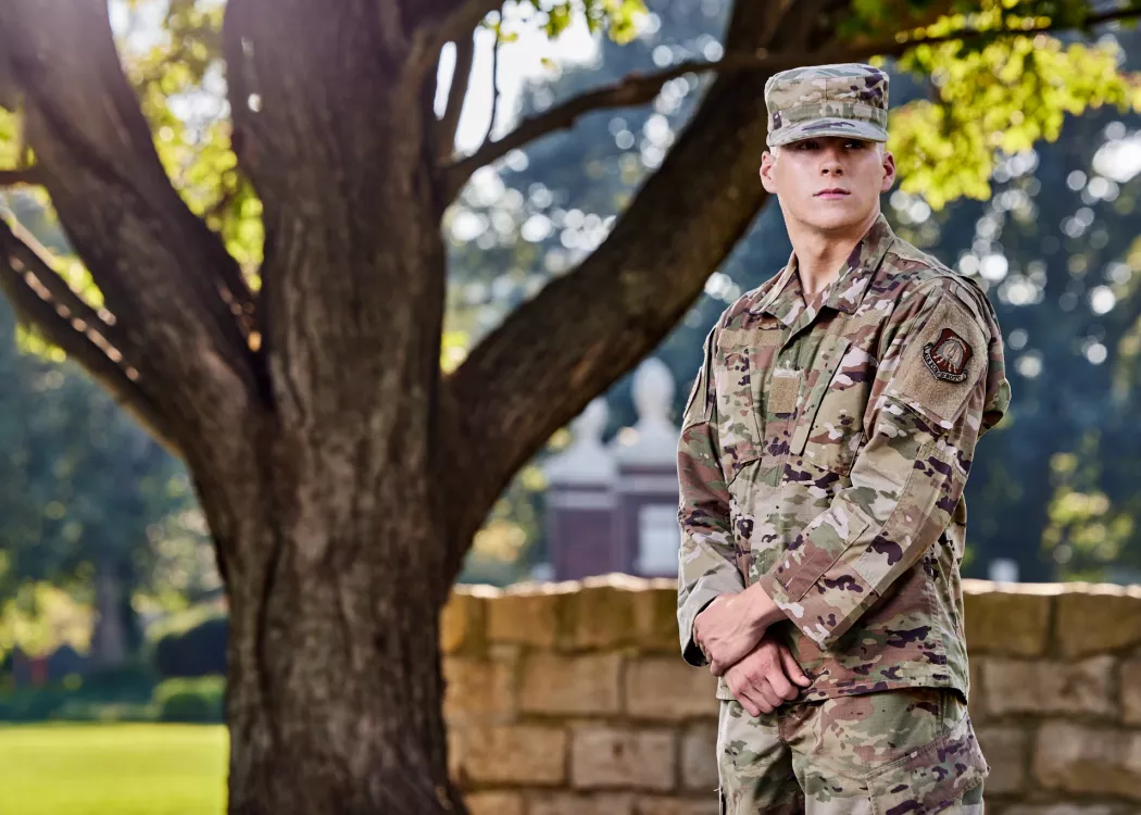Brimm is pictured in his army uniform, in the at ease position, on the university campus.