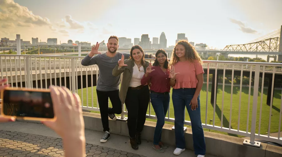 Students throwing up their L's for a group photo opportunity at the Big Four Bridge at Waterfront Park in downtown Louisville.