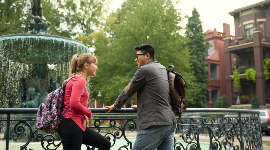 Two students talking beside the fountain in Old Louisville's St. James Court.