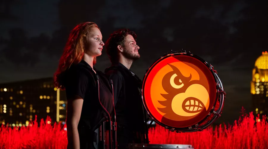 The members are standing side by side as their drums are still and waiting to played.