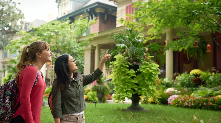 Two students walking through the Old Louisville neighborhood, looking at houses.